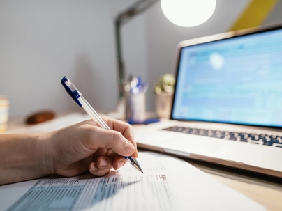 a person working on a document in front of a laptop